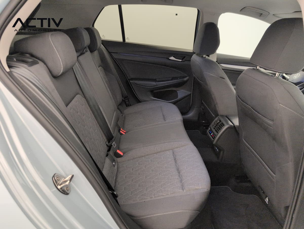 Volkswagen Golf 8 : banquette arrière en tissu foncé vue par la portière arrière ouverte