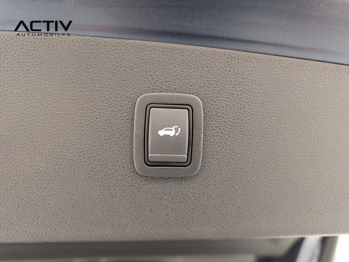 Dacia Bigster : bouton de fermeture du hayon sur la garniture grainée du coffre