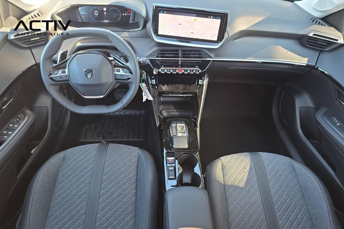 Peugeot 208 : planche de bord vue de dessus avec volant compact, écran tactile et sièges en tissu
