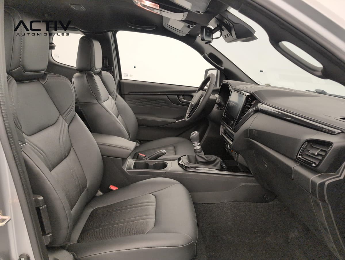 Isuzu D-MAX : habitacle avant vu côté passager avec sièges noirs et levier manuel