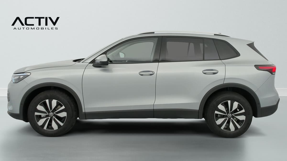Volkswagen Tiguan : profil gauche d'un SUV argent avec jantes alliage et barres de toit