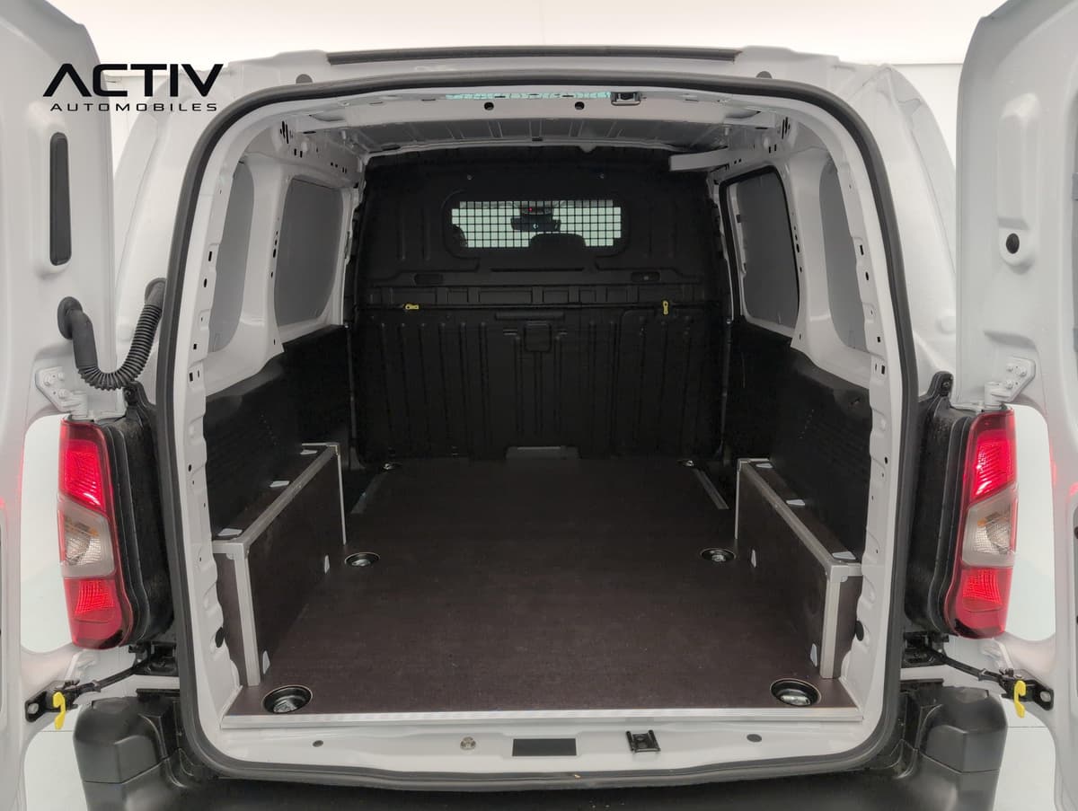 Citroën Berlingo Van : zone de chargement vide avec plancher bois, cloison grillagée et portes battantes ouvertes