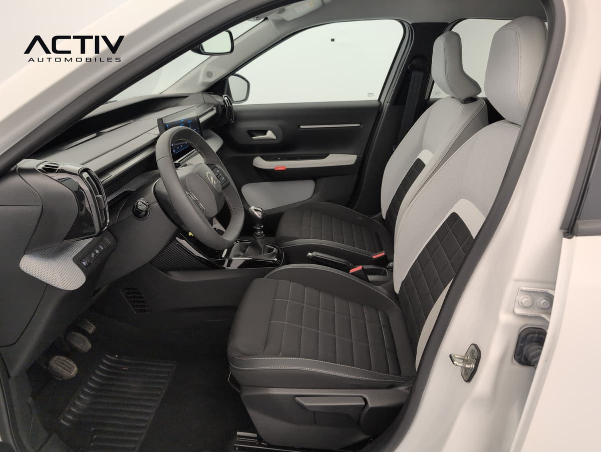 Citroën C3 : sièges avant en tissu noir et gris clair vus depuis la portière conducteur
