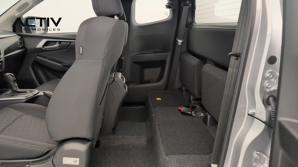 Isuzu D-MAX : sièges arrière relevables en tissu gris foncé vus par la portière ouverte