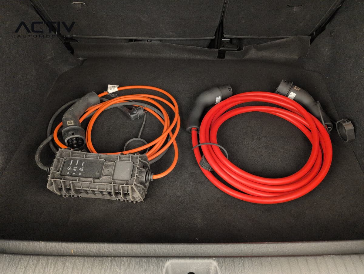 Citroën E-C3 Aircross : coffre ouvert avec deux câbles de charge rangés sur la moquette noire
