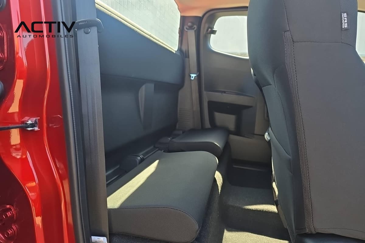 Isuzu D-MAX : sièges arrière rabattables en tissu noir de la cabine, vus par la portière ouverte