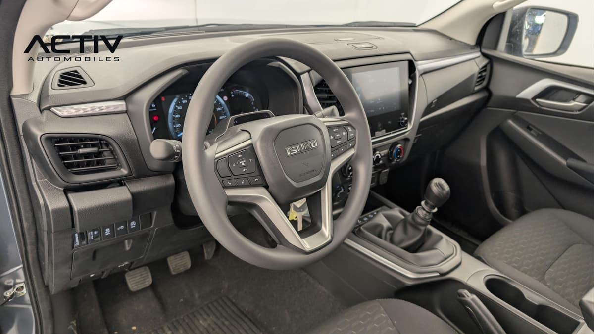 Isuzu D-MAX : habitacle avant côté conducteur avec volant, écran et levier de vitesses manuel