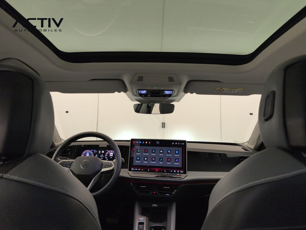 Volkswagen Passat : habitacle vu depuis l'arrière avec toit vitré, écran tactile et volant
