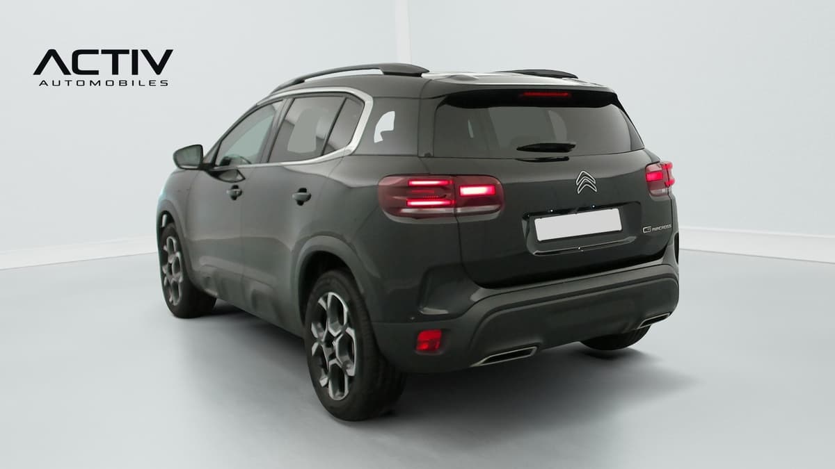 Citroën C5 Aircross : arrière trois quarts gauche d'un SUV sombre avec barres de toit et jantes alliage