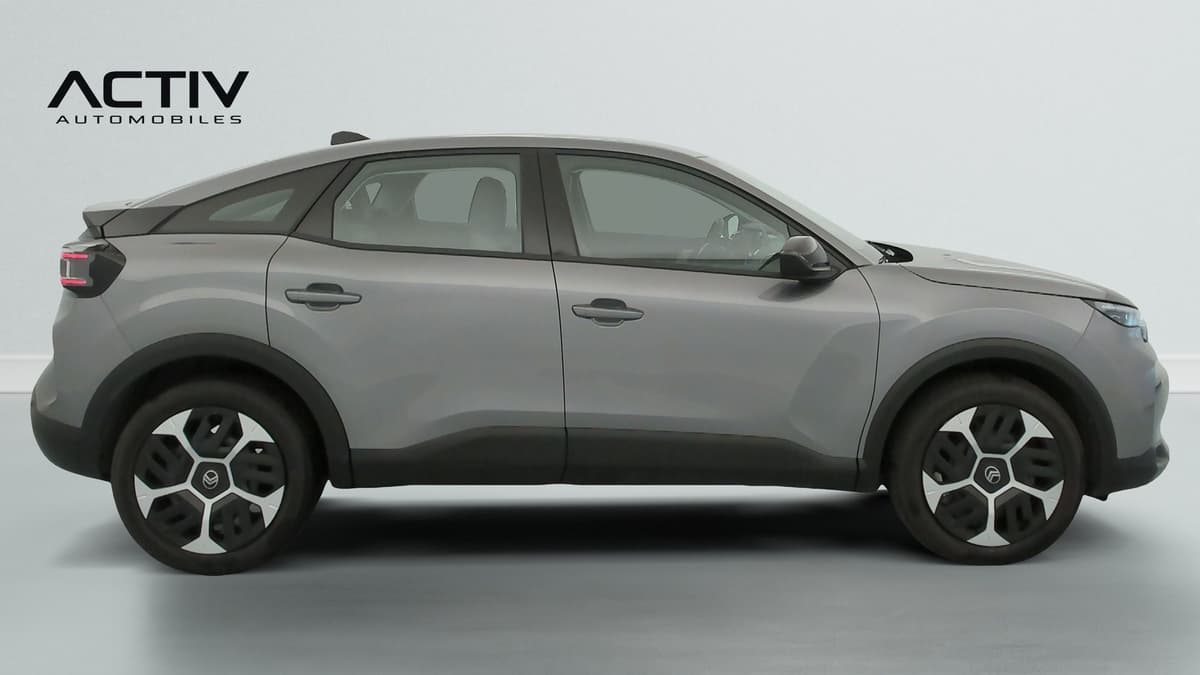 Citroën C4 : profil droit de la berline grise avec enjoliveurs bicolores et bas de caisse noir