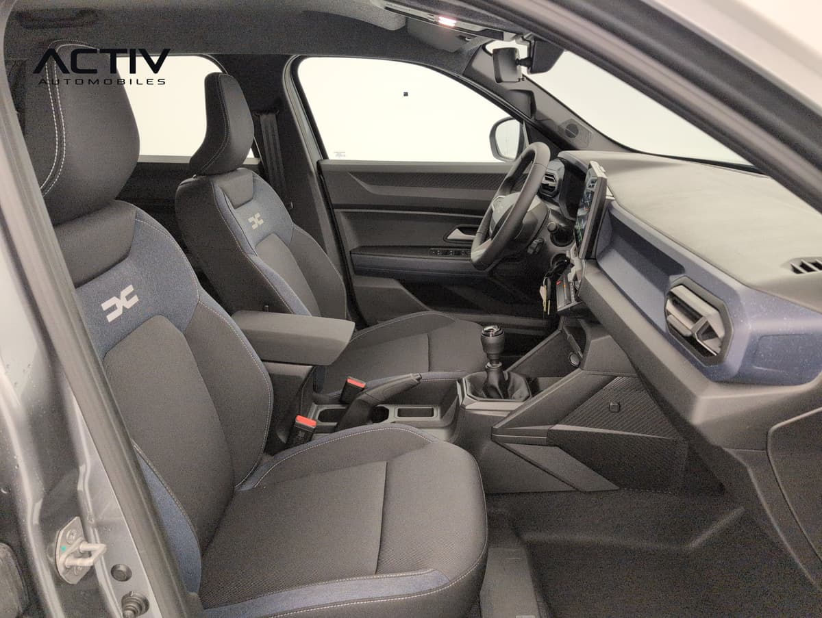 Dacia Duster : sièges avant en tissu denim bleu et noir vus depuis la portière passager