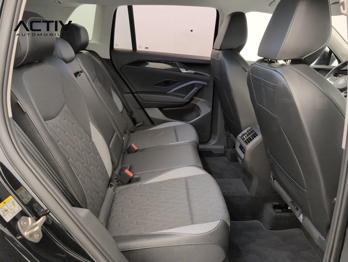 Volkswagen Tiguan : banquette arrière en tissu gris et noir vue par la portière gauche ouverte