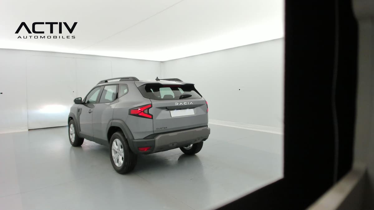 Dacia Duster : arrière trois quarts gauche d'un SUV gris avec barres de toit