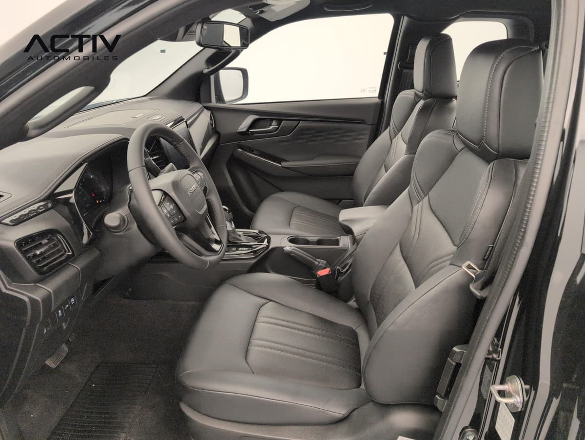 Isuzu D-MAX : sièges avant noirs et volant vus par la portière conducteur ouverte