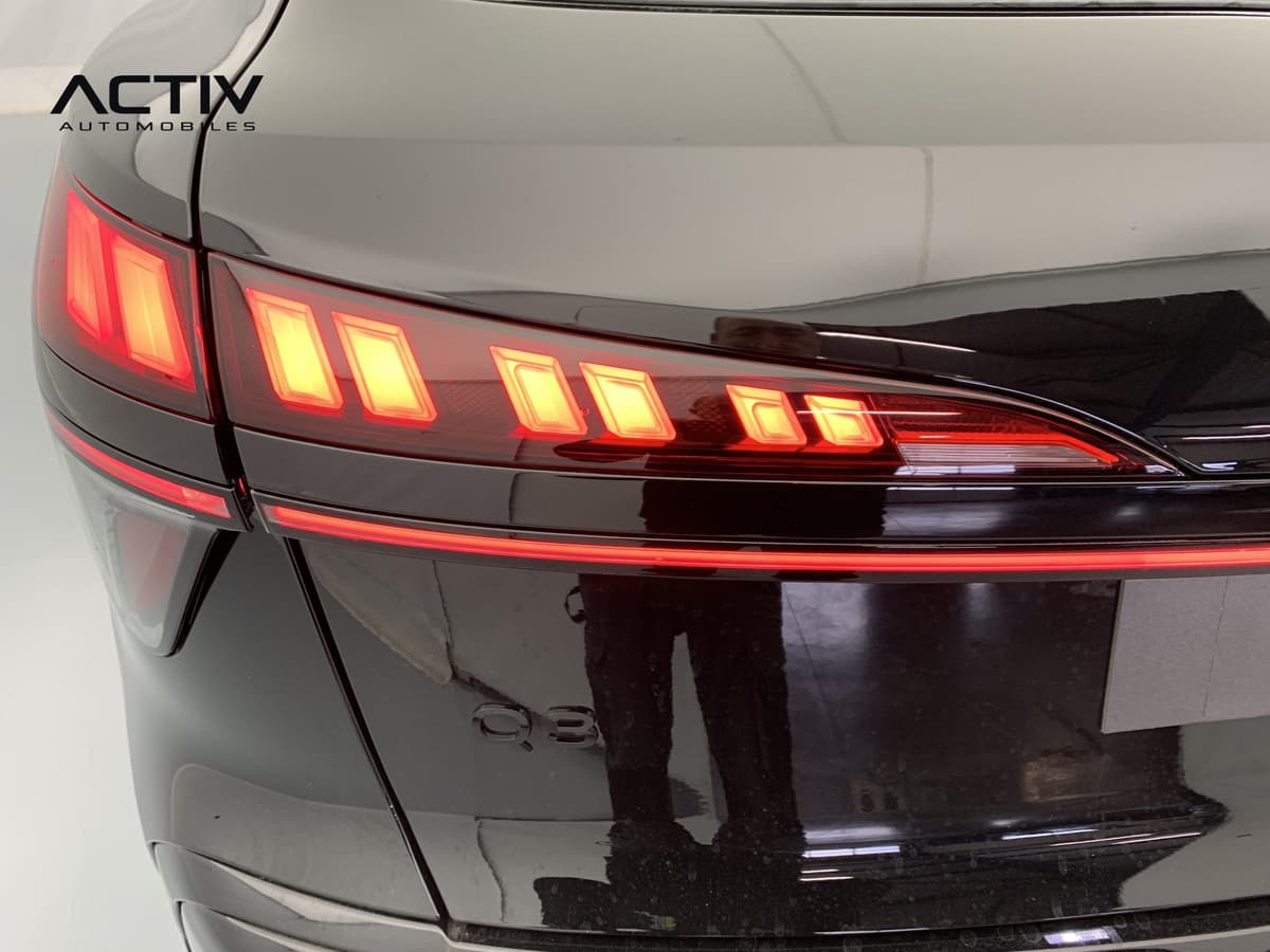 Audi Q3 Sportback Hybride : feu arrière à LED allumé avec bande lumineuse rouge sur le hayon