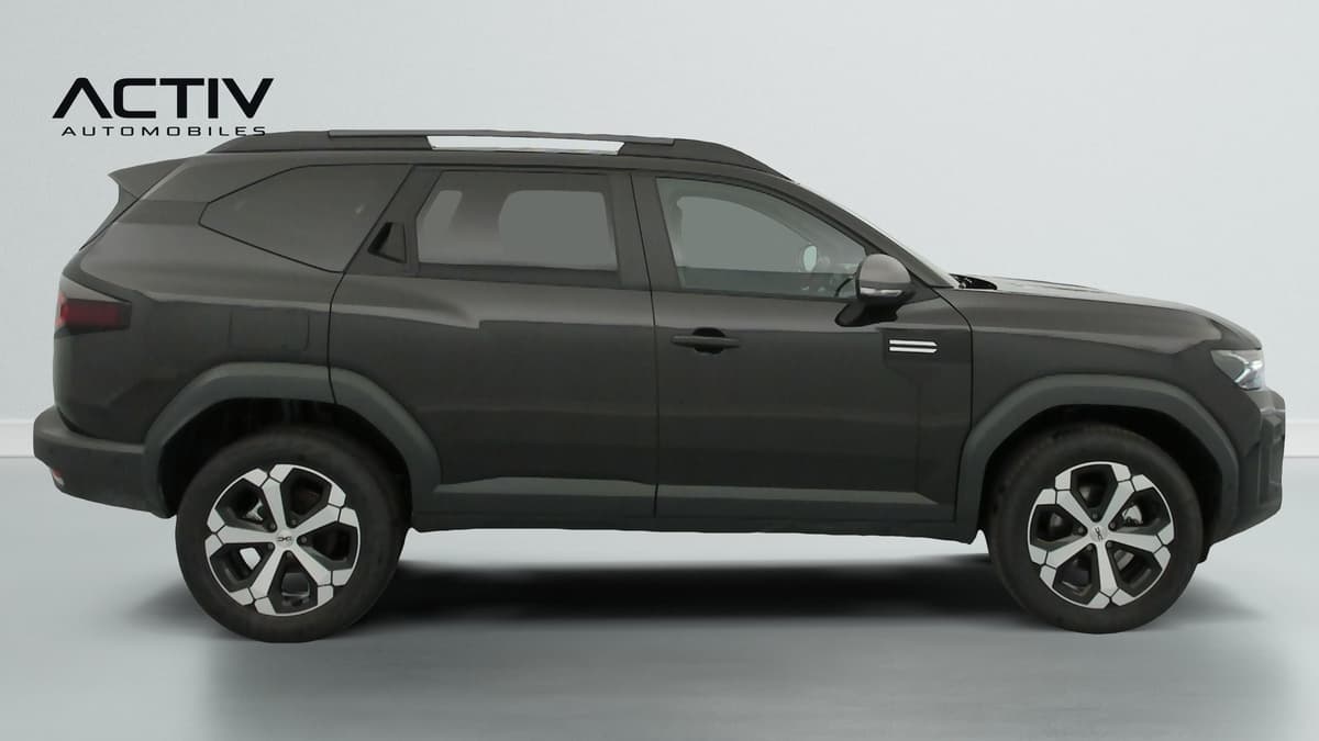 Dacia Bigster Hybrid : profil droit du SUV noir avec jantes alliage bicolores et barres de toit