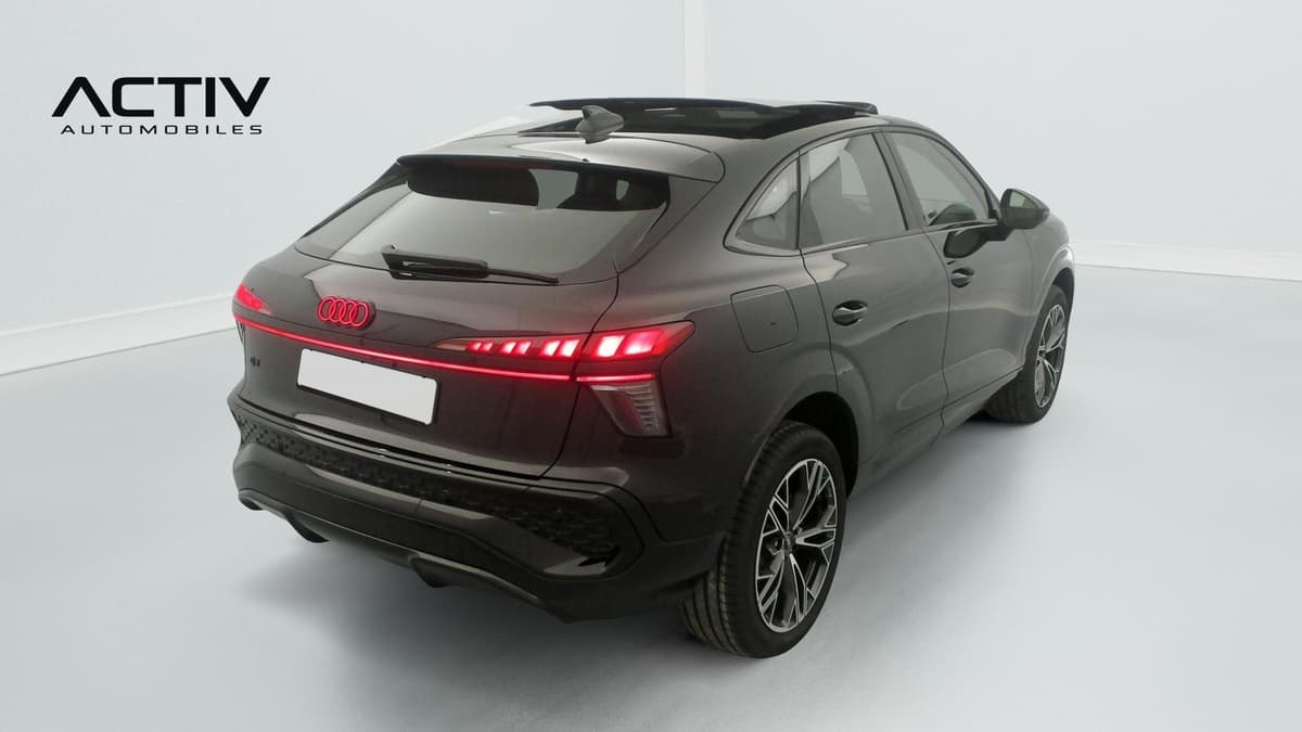 Audi Q3 Sportback Hybride : vue arrière trois quarts droit avec feux rouges allumés et jantes bicolores