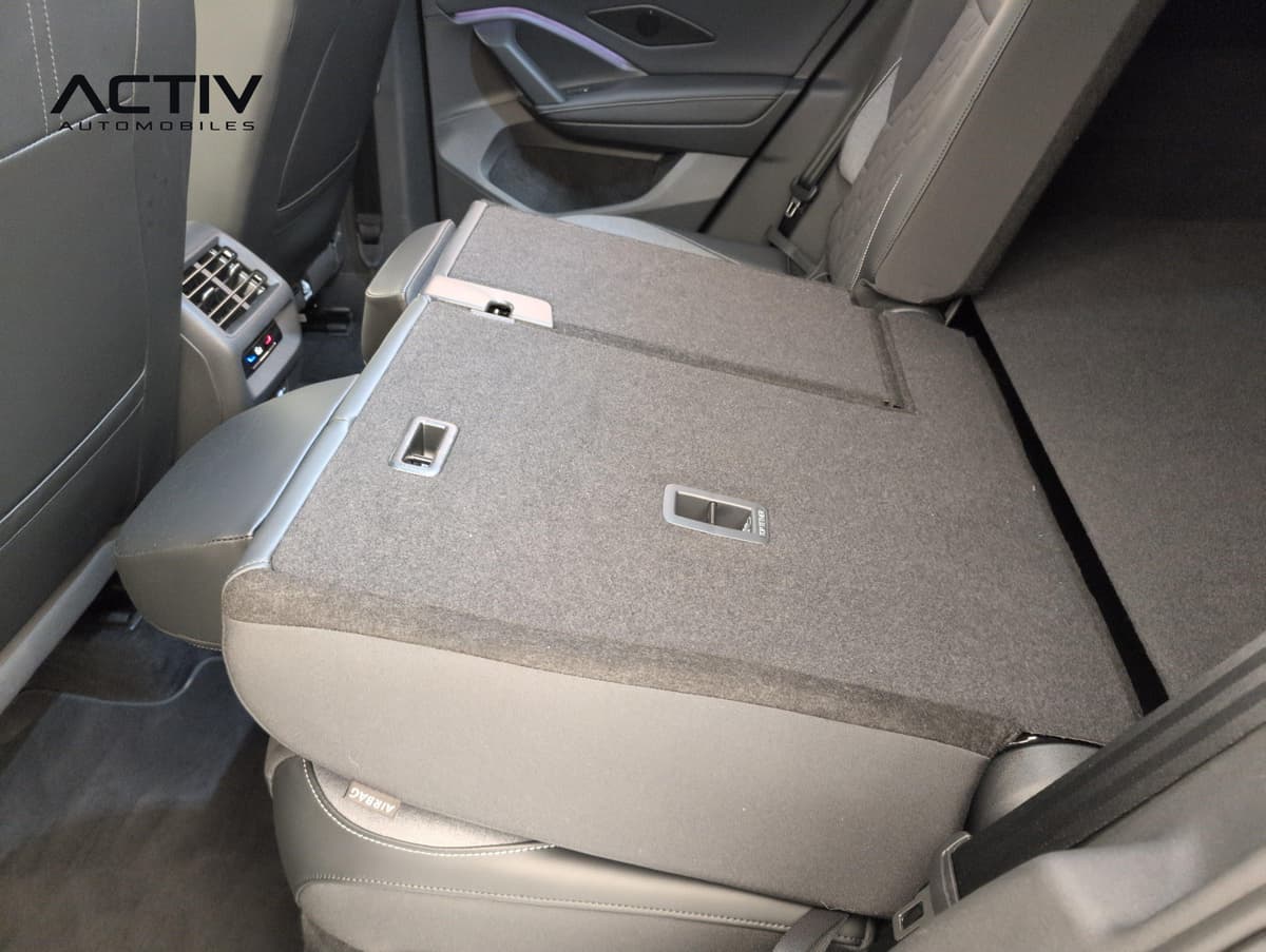 Volkswagen Tiguan : dossier de banquette arrière rabattu avec moquette grise, vu de l'habitacle