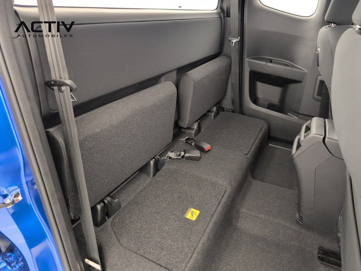 Isuzu D-MAX : sièges arrière rabattables en tissu gris foncé vus par la portière ouverte