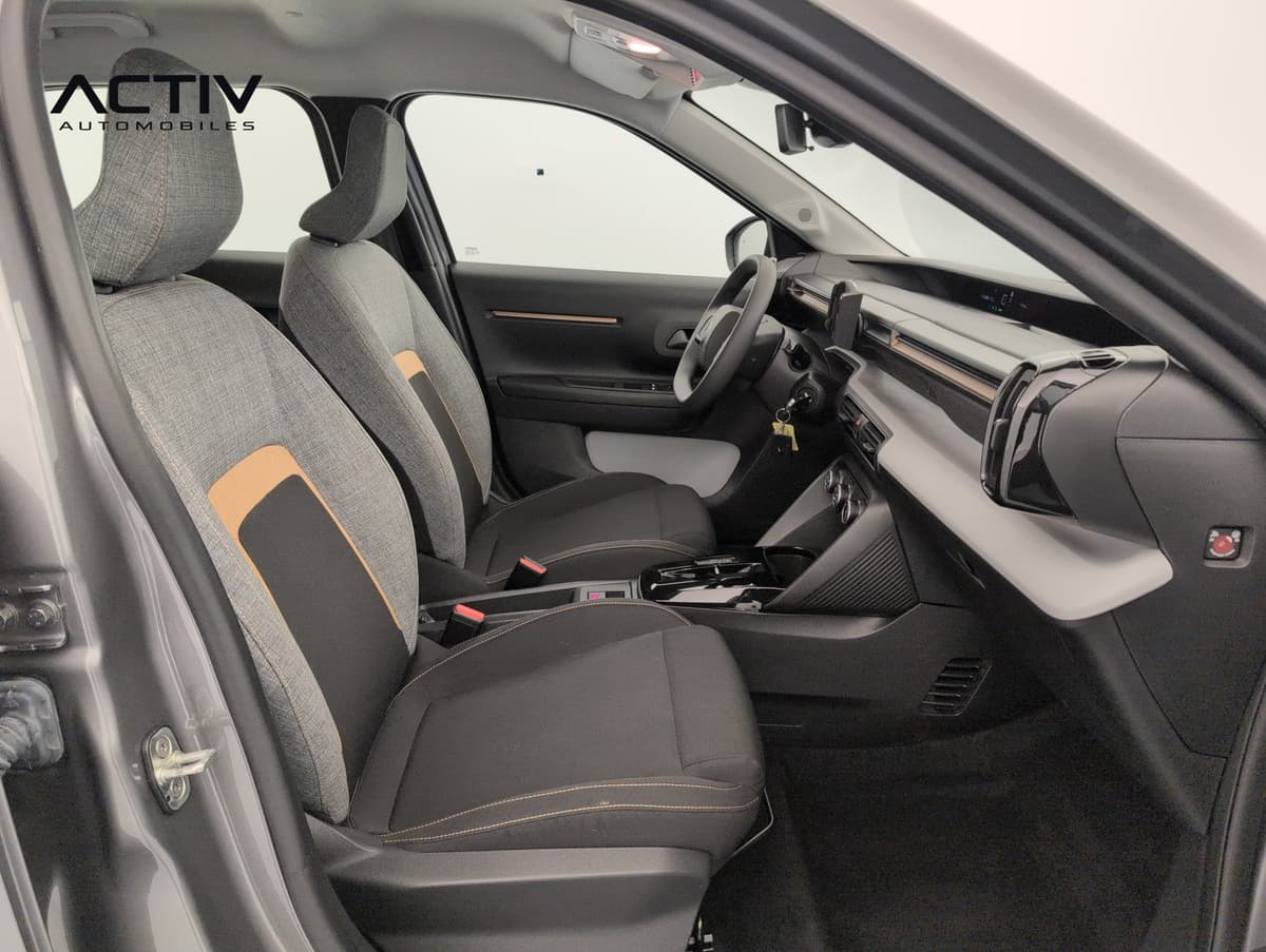 Citroën E-C3 Aircross : sièges avant en tissu gris et noir avec surpiqûres orange, vus côté passager