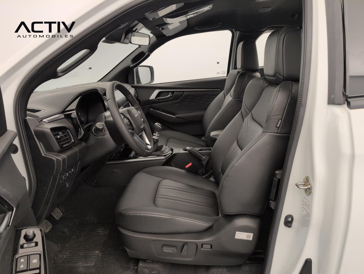 Isuzu D-MAX : habitacle avant côté conducteur avec sièges en cuir noir et levier manuel