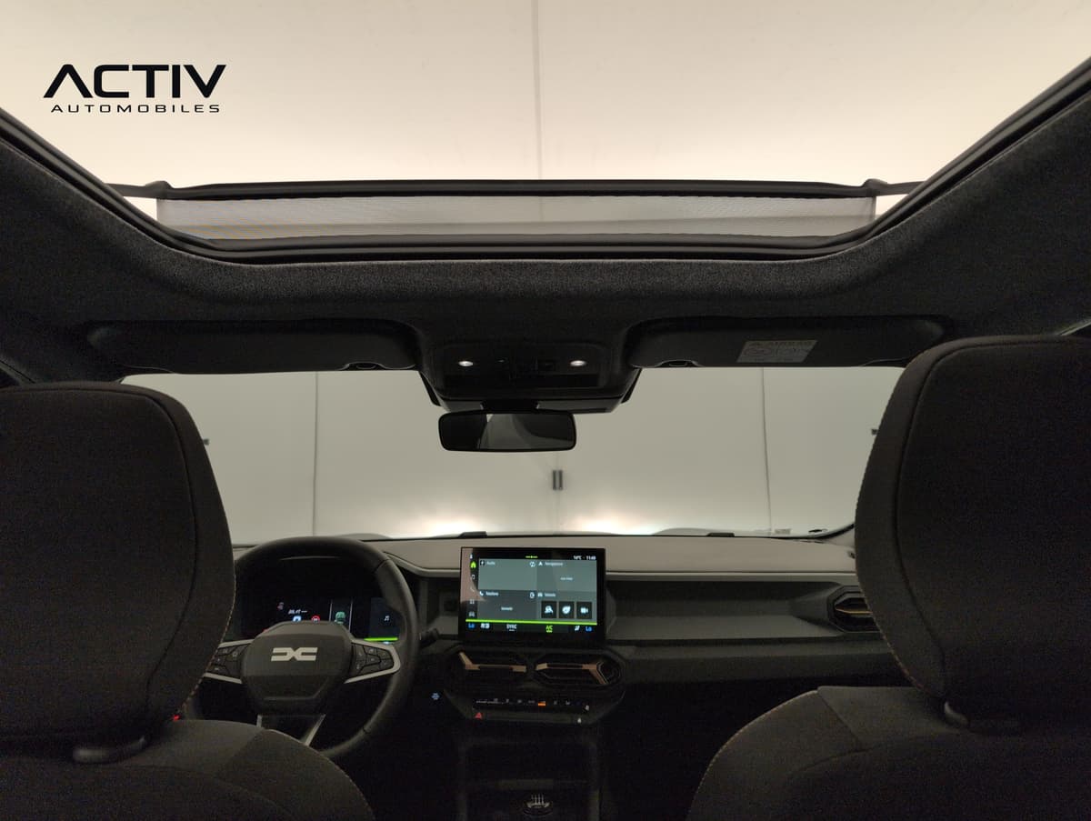 Dacia Bigster : toit vitré vu de l'intérieur depuis l'arrière, avec planche de bord et écran
