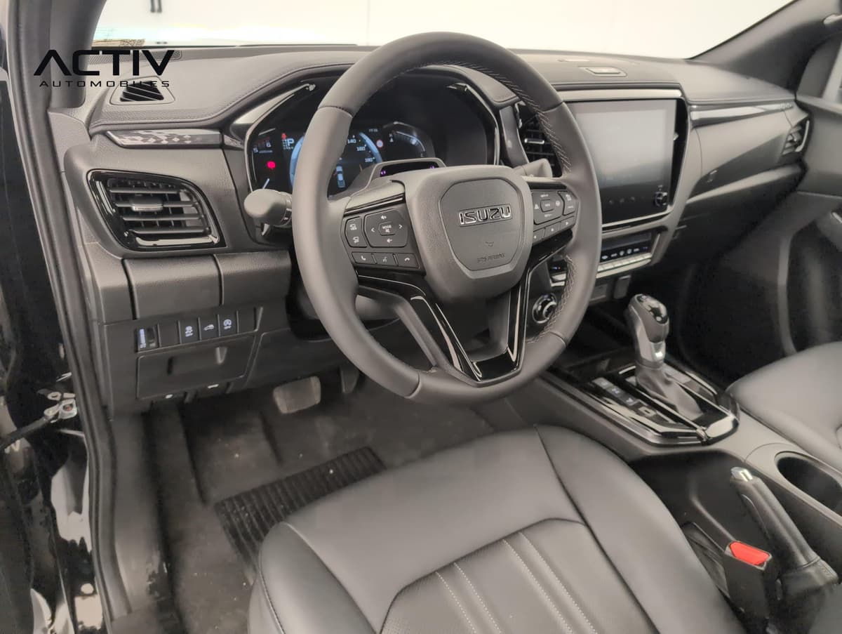 Isuzu D-MAX : habitacle avant côté conducteur avec volant, écran tactile et siège en cuir noir