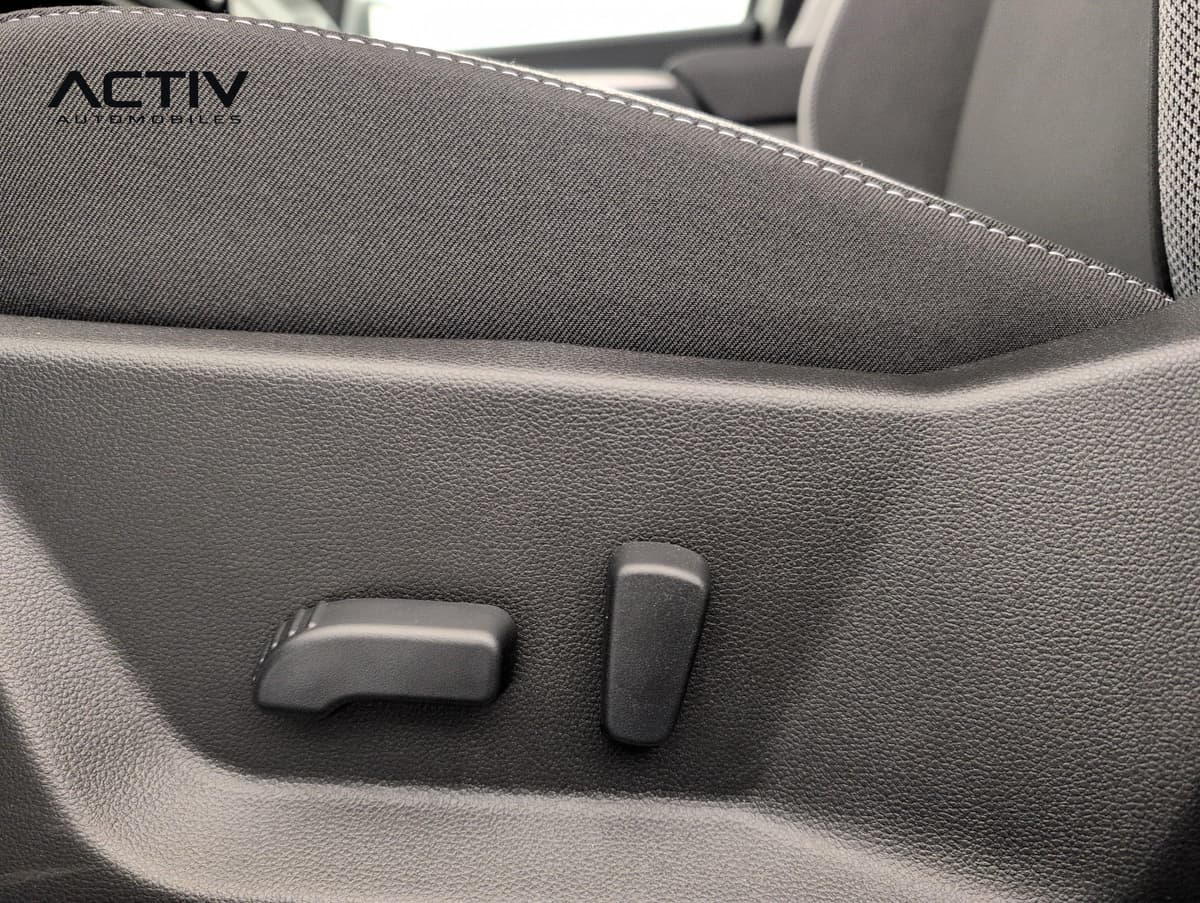 Dacia Bigster Hybrid : commandes de réglage du siège conducteur sur le flanc de l'assise en tissu