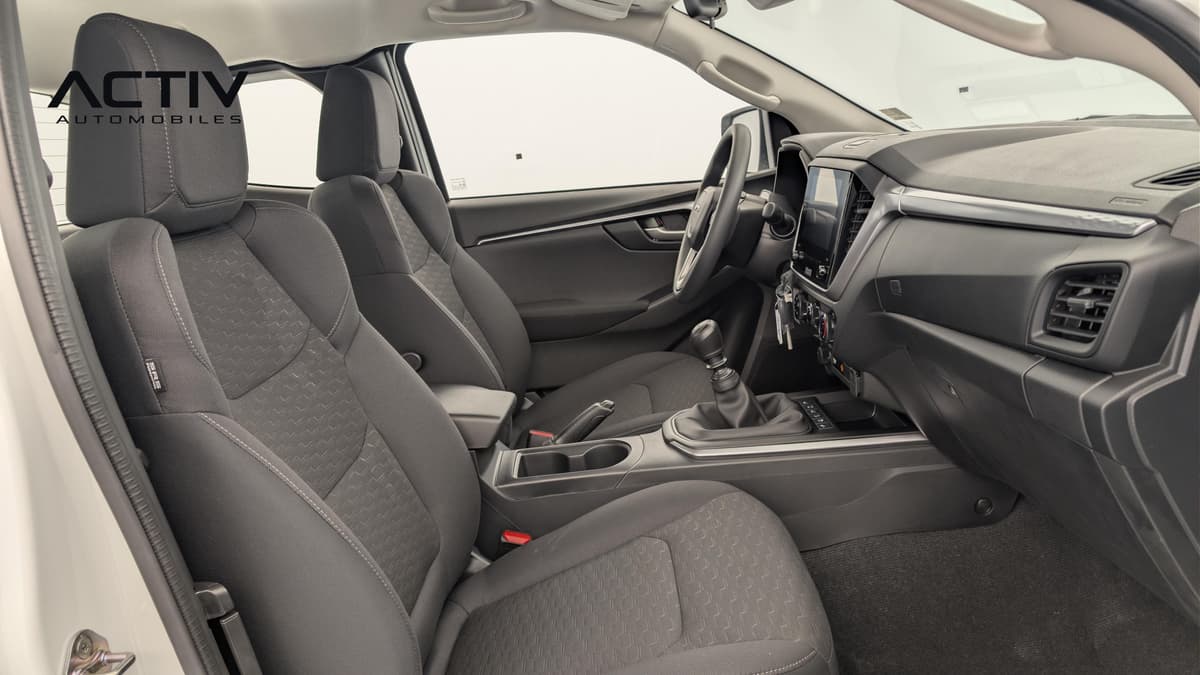 Isuzu D-MAX : habitacle avant côté passager avec sièges en tissu noir et levier de vitesses manuel