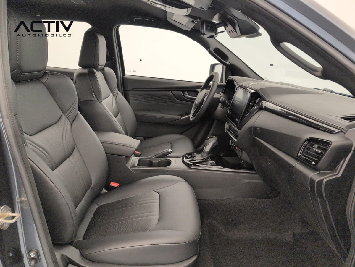Isuzu D-MAX : sièges avant en cuir noir, console centrale et planche de bord vus côté passager