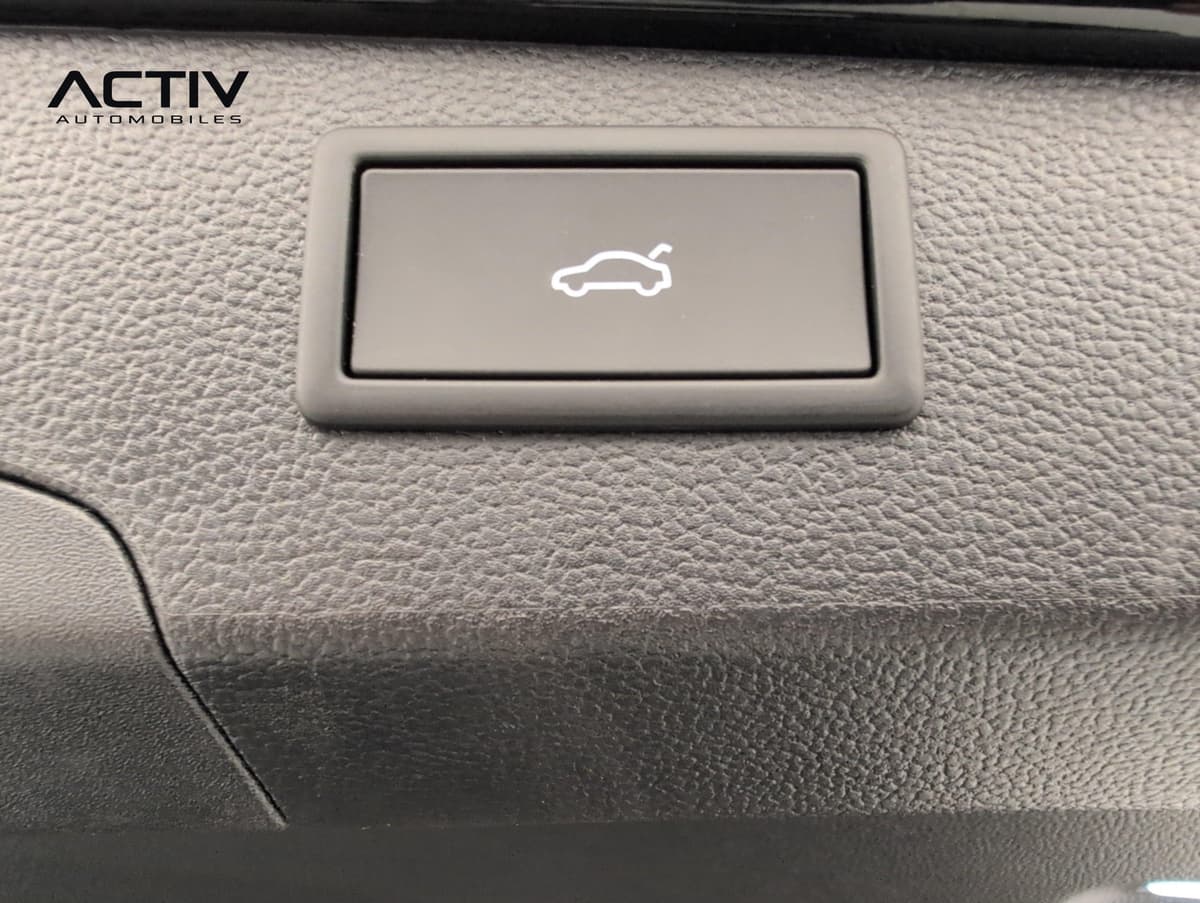 Volkswagen Passat : bouton de fermeture du hayon sur la garniture grainée du coffre
