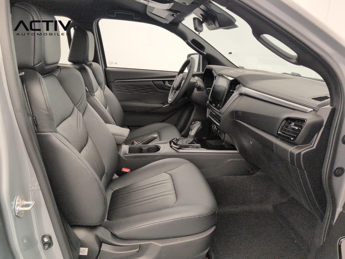 Isuzu D-MAX : sièges avant en cuir noir et planche de bord avec écran tactile, vus côté passager