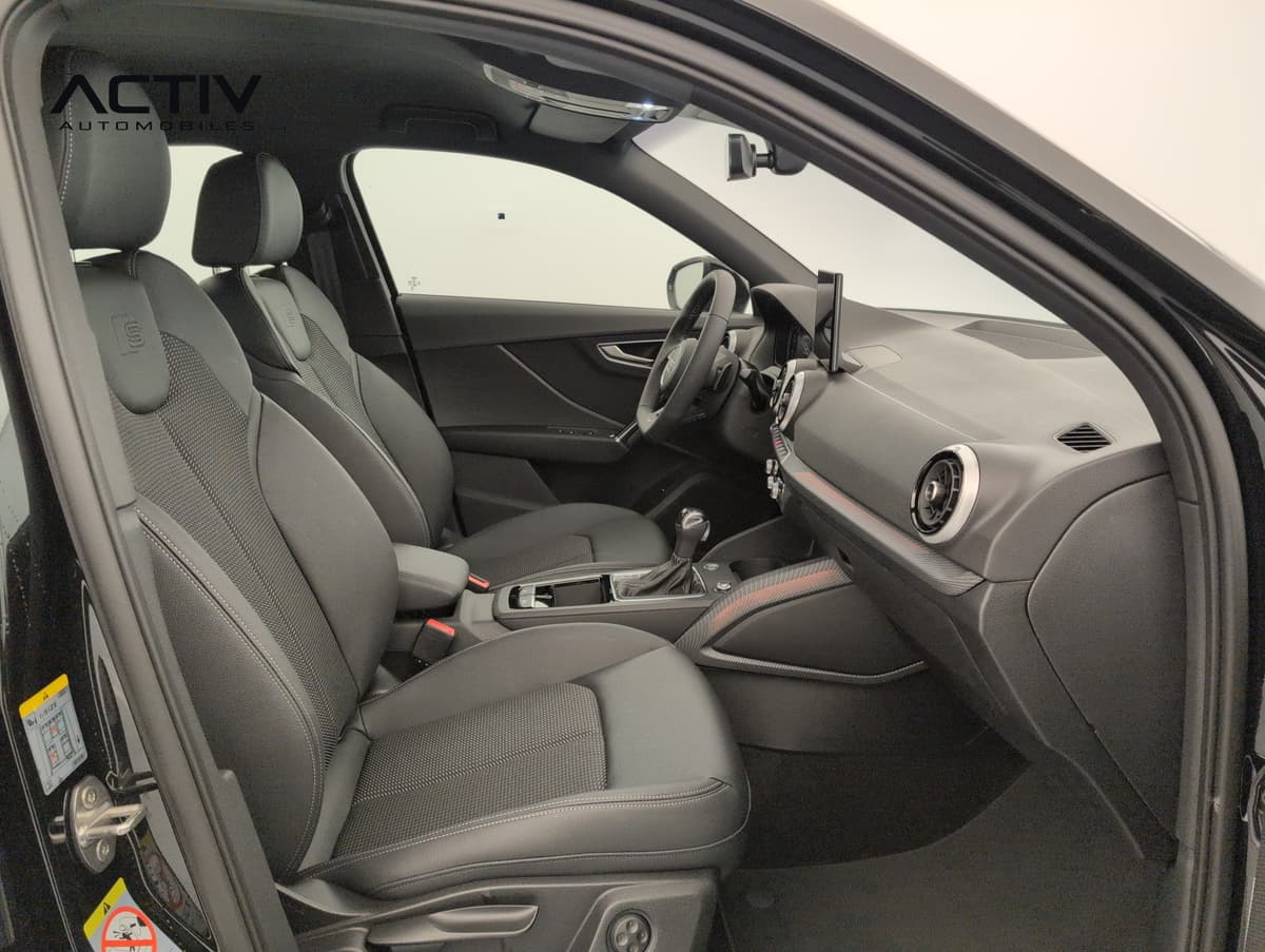 Audi Q2 : sièges avant sport noirs et planche de bord vus depuis la portière passager
