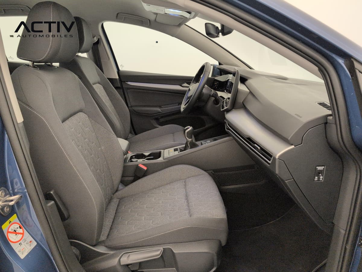 Volkswagen Golf 8 : habitacle avant côté passager avec siège en tissu gris et levier de vitesses manuel