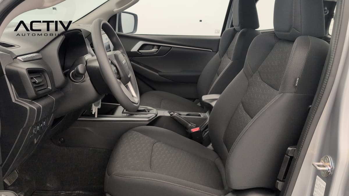 Isuzu D-MAX : sièges avant en tissu noir et volant vus depuis la portière conducteur