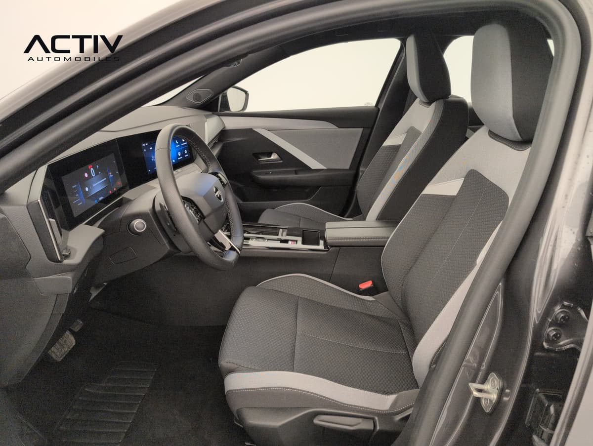 Opel Astra : habitacle avant côté conducteur avec sièges en tissu gris et noir