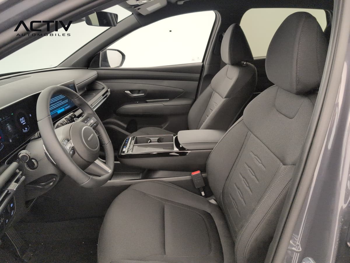 Hyundai Tucson : habitacle avant côté conducteur avec sièges en tissu noir et console centrale