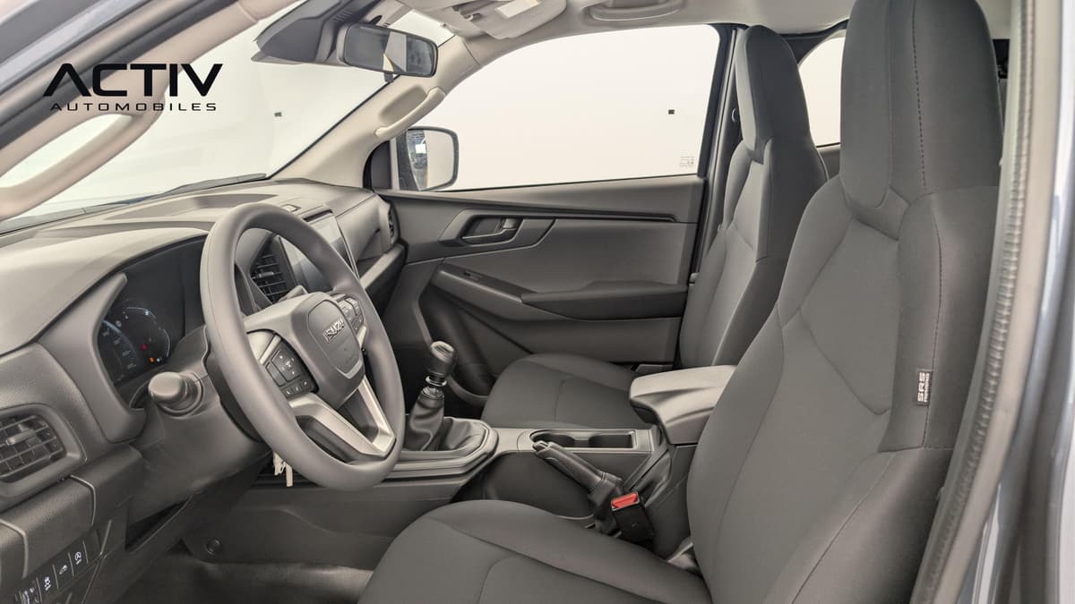 Isuzu D-MAX : habitacle avant côté conducteur avec sièges en tissu sombre et levier manuel