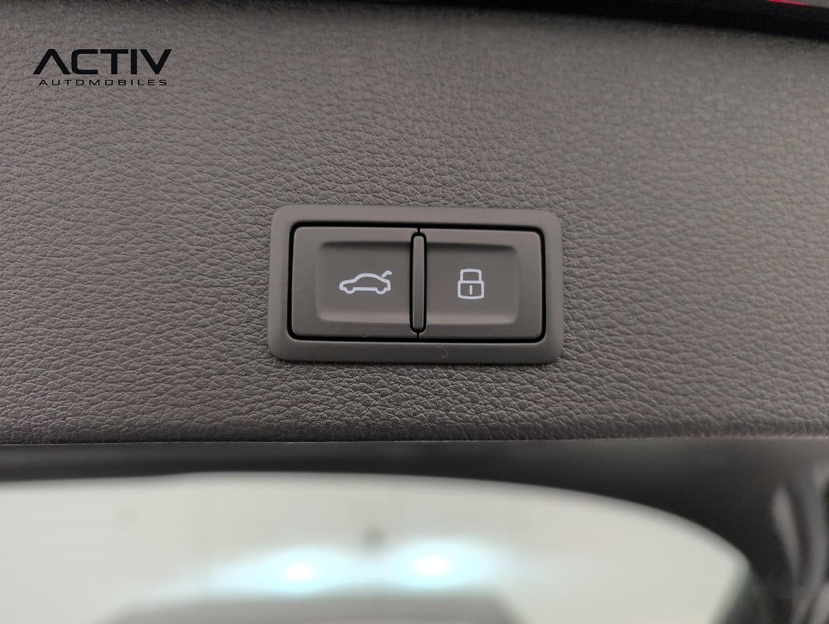 Audi Q2 : boutons d'ouverture du hayon et de verrouillage sur la garniture du coffre