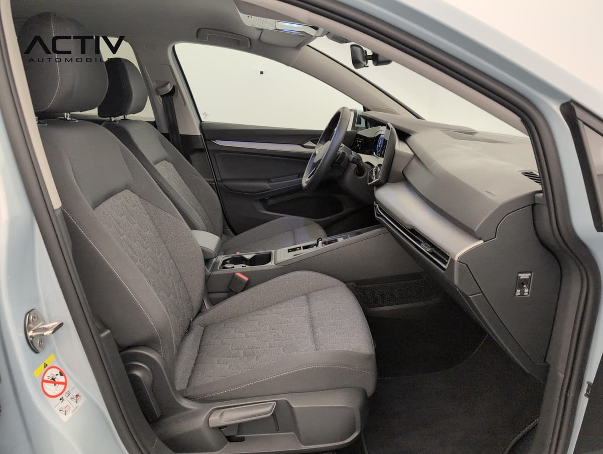 Volkswagen Golf 8 : siège passager avant en tissu gris et planche de bord vus par la portière