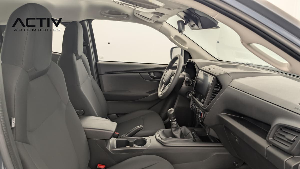 Isuzu D-MAX : habitacle avant côté passager avec sièges en tissu gris et levier de vitesses manuel