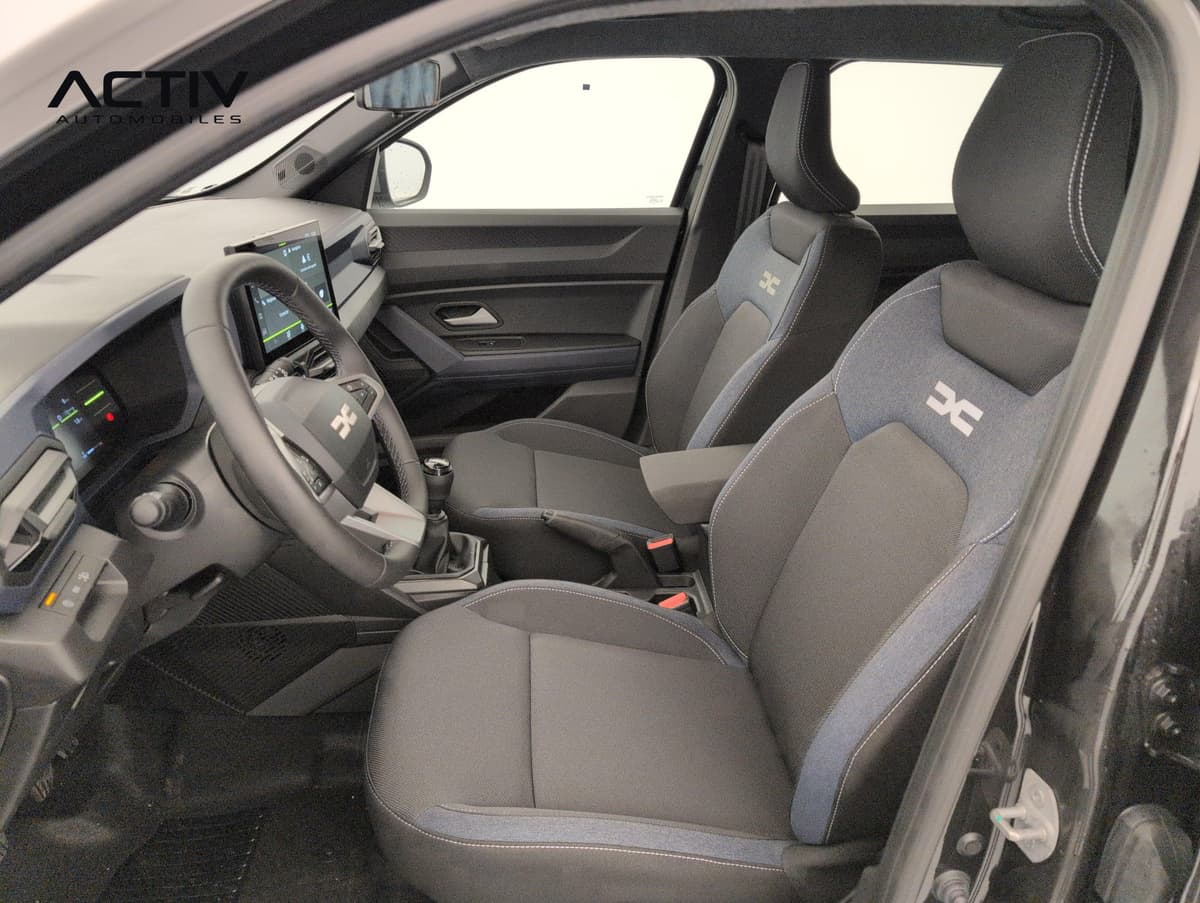 Dacia Duster : sièges avant en tissu gris et bleu denim vus par la portière conducteur ouverte