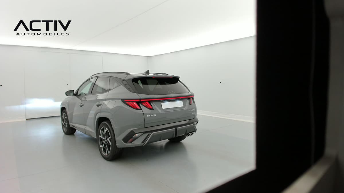 Hyundai Tucson : vue arrière trois quarts gauche d'un SUV gris avec feux à LED et jantes alliage