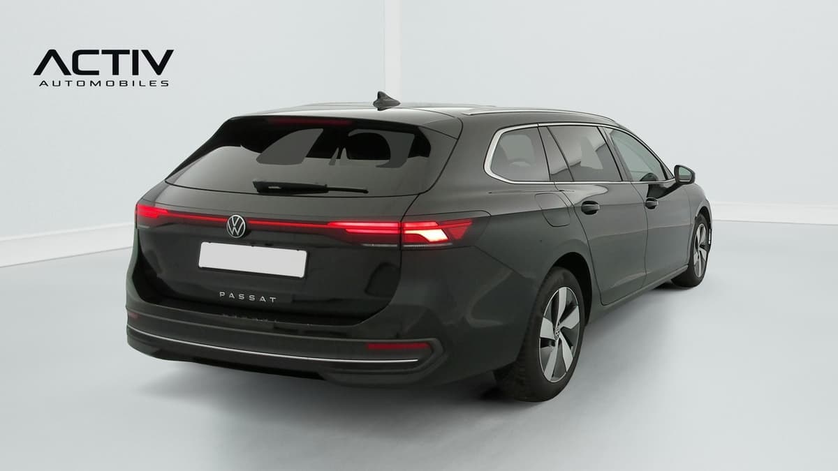 Volkswagen Passat : break noir vu de l'arrière trois quarts droit, avec feux à LED et rampes de toit