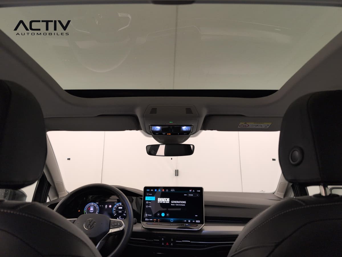 Volkswagen Golf : toit vitré vu de l'intérieur, avec la planche de bord et l'écran au fond