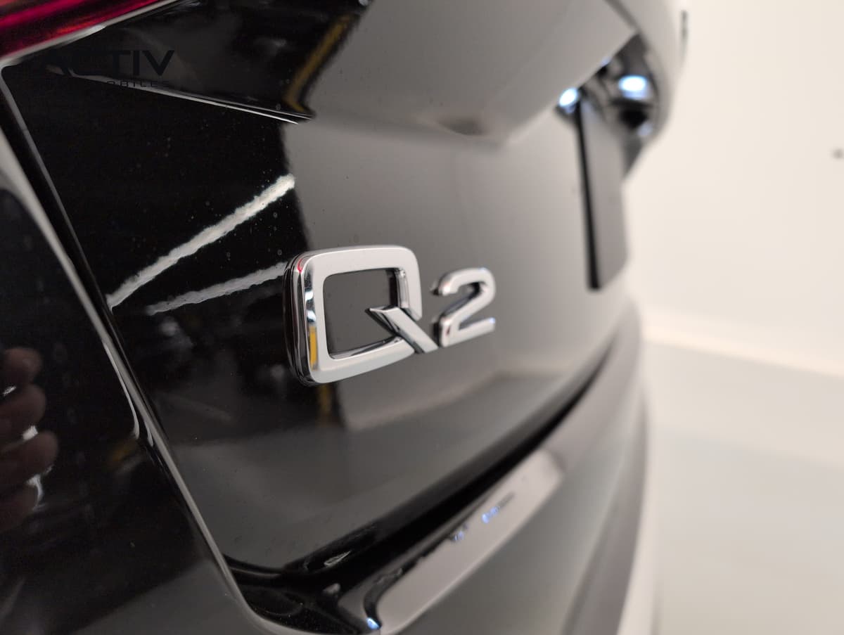 Audi Q2 : monogramme chromé sur le hayon noir brillant, vu de près