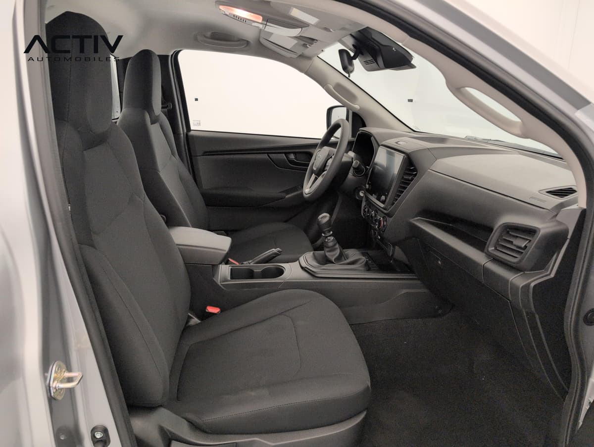 Isuzu D-MAX : habitacle avant vu côté passager avec sièges en tissu noir et levier manuel