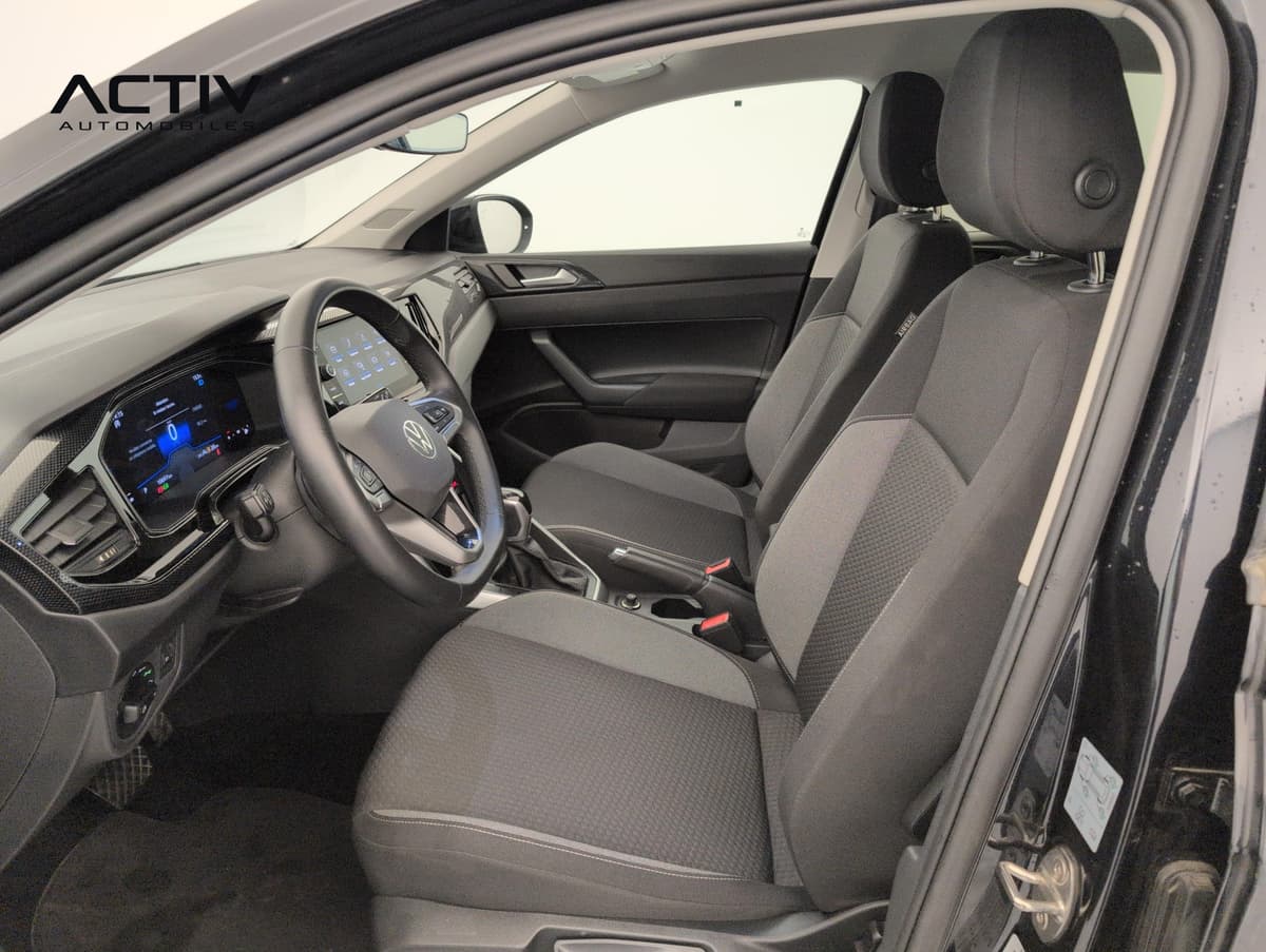 Volkswagen Taigo : sièges avant en tissu gris foncé vus depuis la portière conducteur ouverte