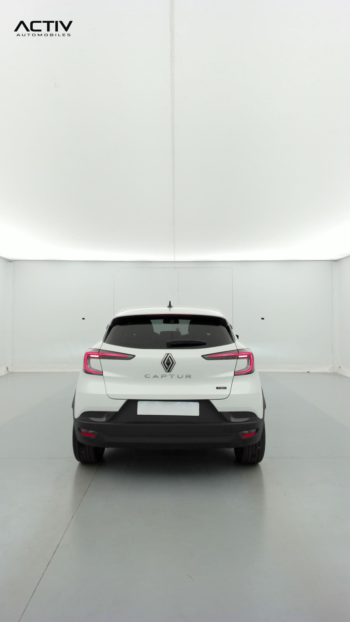 Renault Captur : face arrière du SUV blanc avec feux allumés et pare-chocs noir