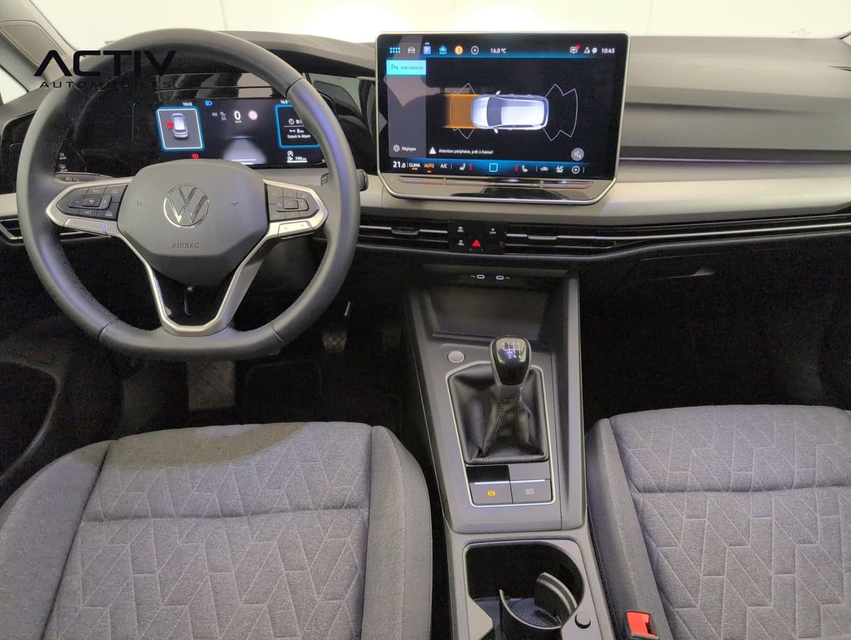 Volkswagen Golf 8 : planche de bord avec volant, écran tactile et levier de vitesses manuel